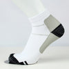 Chaussettes de compression blanches avec des rayures grises et noires sur une jambe blanche.