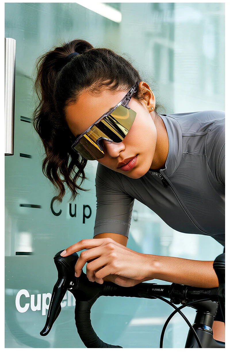 A woman wearing polarized performance sunglasses is shown leaning over a bicycle handlebar.