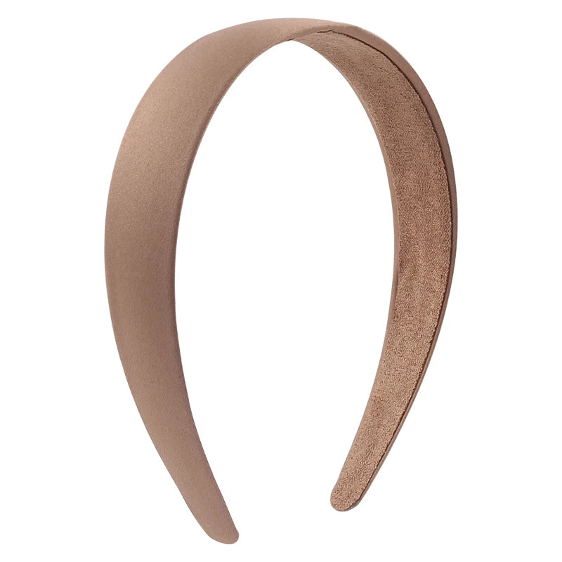 A beige satin hair band is shown in a curved shape against a white background.