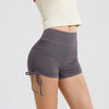 Gray performance yoga shorts worn by a person, showing the fit and drawstring detail.