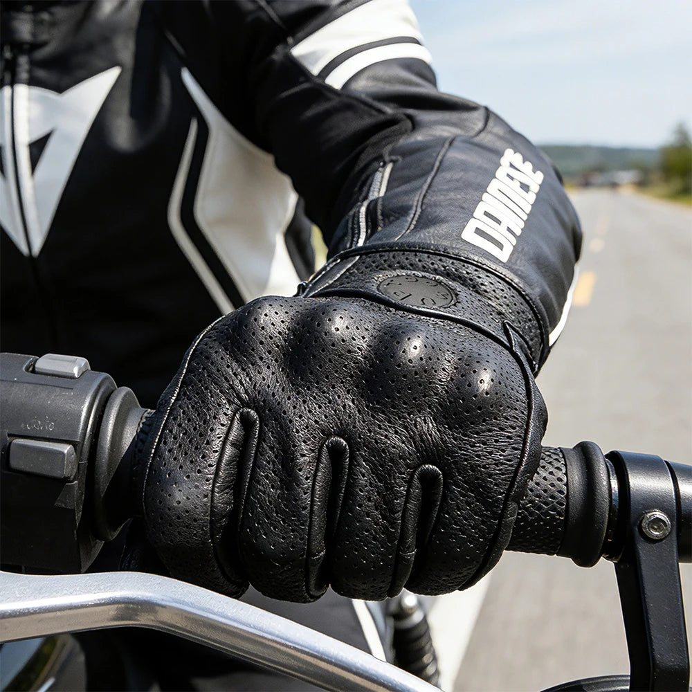 Black leather riding gloves worn by a person on a motorcycle.