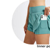 Eine Person trägt tealfarbene, hochgeschnittene Sportshorts mit einer Innentasche für ein Smartphone.
