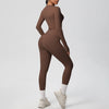 A woman wearing a full-length, long-sleeved performance yoga and gym set in a solid brown color.