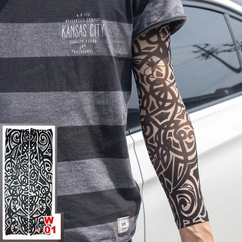 A person is wearing a gray t-shirt featuring text and a black geometric tattoo sleeve on their arm.