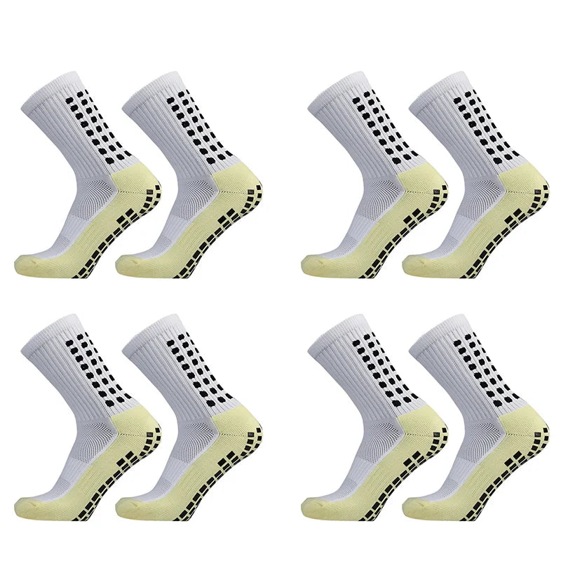 Ein Set von vier hellgrauen Sportsocken mit gelben Akzenten und einem schwarzen Punktmuster.