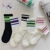A collection of striped casual socks in black, white, and various colors are displayed on a white surface.