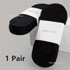 A pair of black boat socks with white labels displayed on a white background.