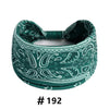 A dark green boho print cotton headband with a bow detail.