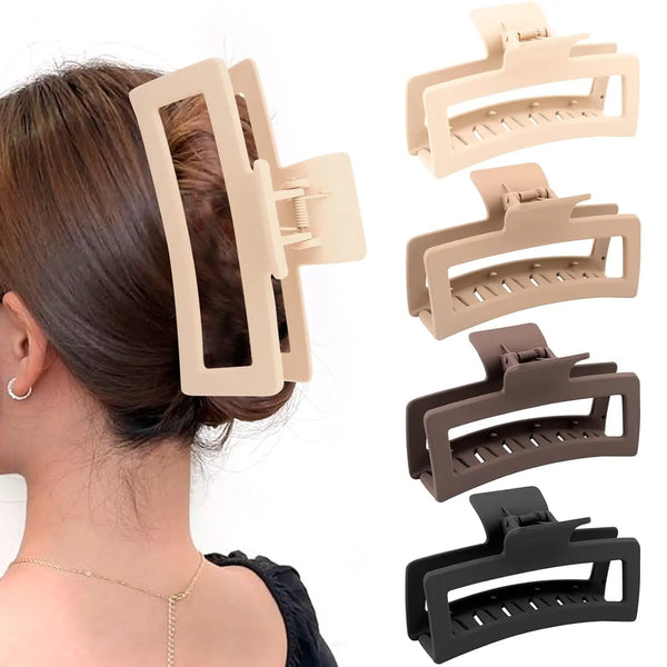Un set de quatre pinces à cheveux mattes extra-larges dans différentes nuances de beige et de brun pour coiffer les cheveux é