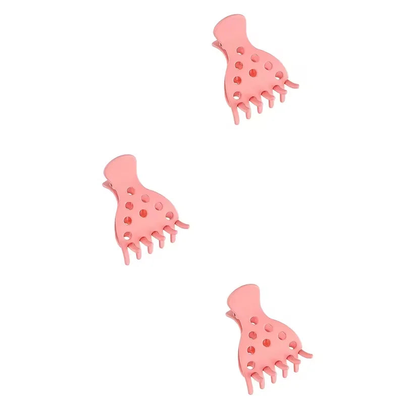 A set of pink root lifting hairpin curling clamps with small teeth.