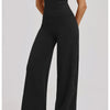 A woman models a black women's premium fitness tracksuit featuring a short-sleeved top and loose-fitting pants.
