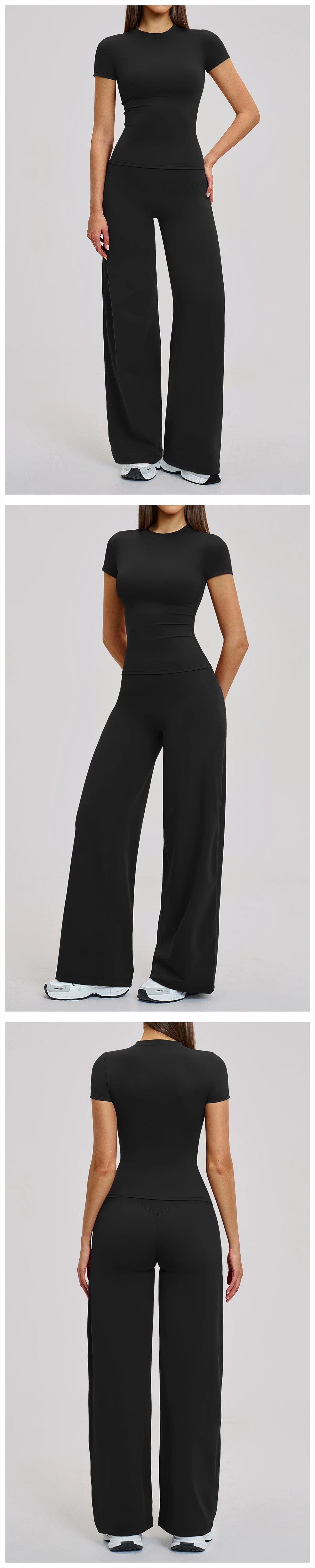 A woman models a black women's premium fitness tracksuit featuring a short-sleeved top and loose-fitting pants.