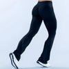 A person wearing black seamless flared yoga leggings and white athletic shoes.
