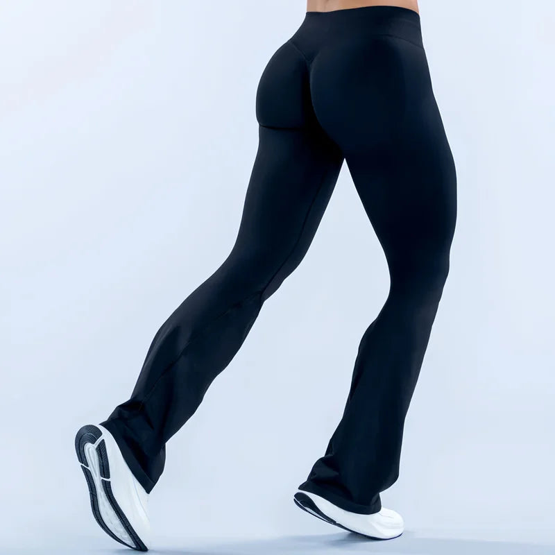 A person wearing black seamless flared yoga leggings and white athletic shoes.