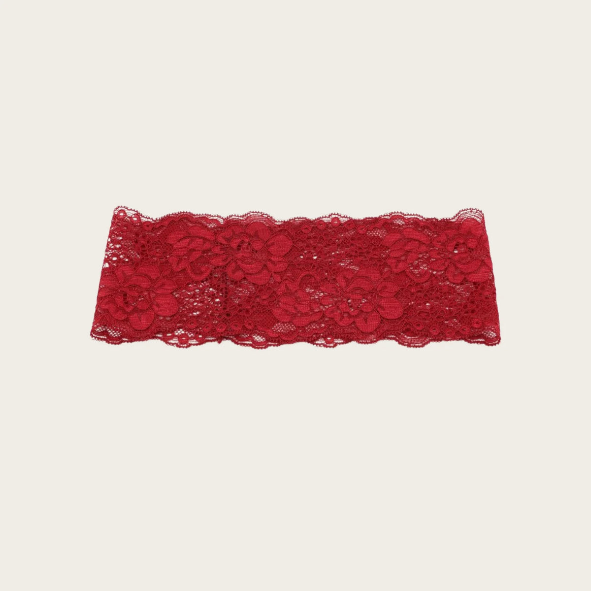 Una pieza de tela de encaje rojo usada como diadema o ribete.