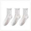 A pack of three white cotton ankle socks with ruffled cuffs.