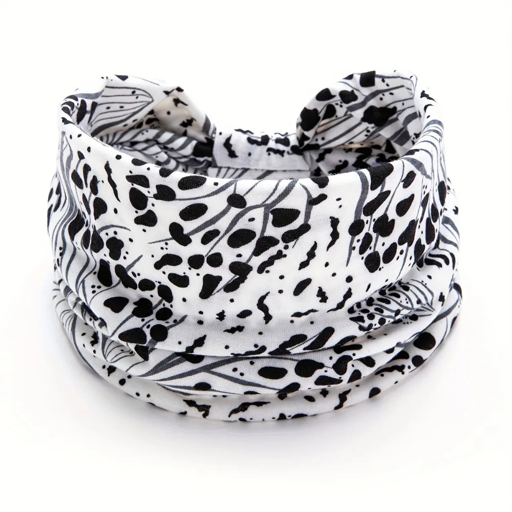 A close-up of a black and white leopard print fabric used as a stylish scarf or headband.