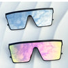 A pair of retro square sunglasses with a blue sky and white cloud pattern against a white background.