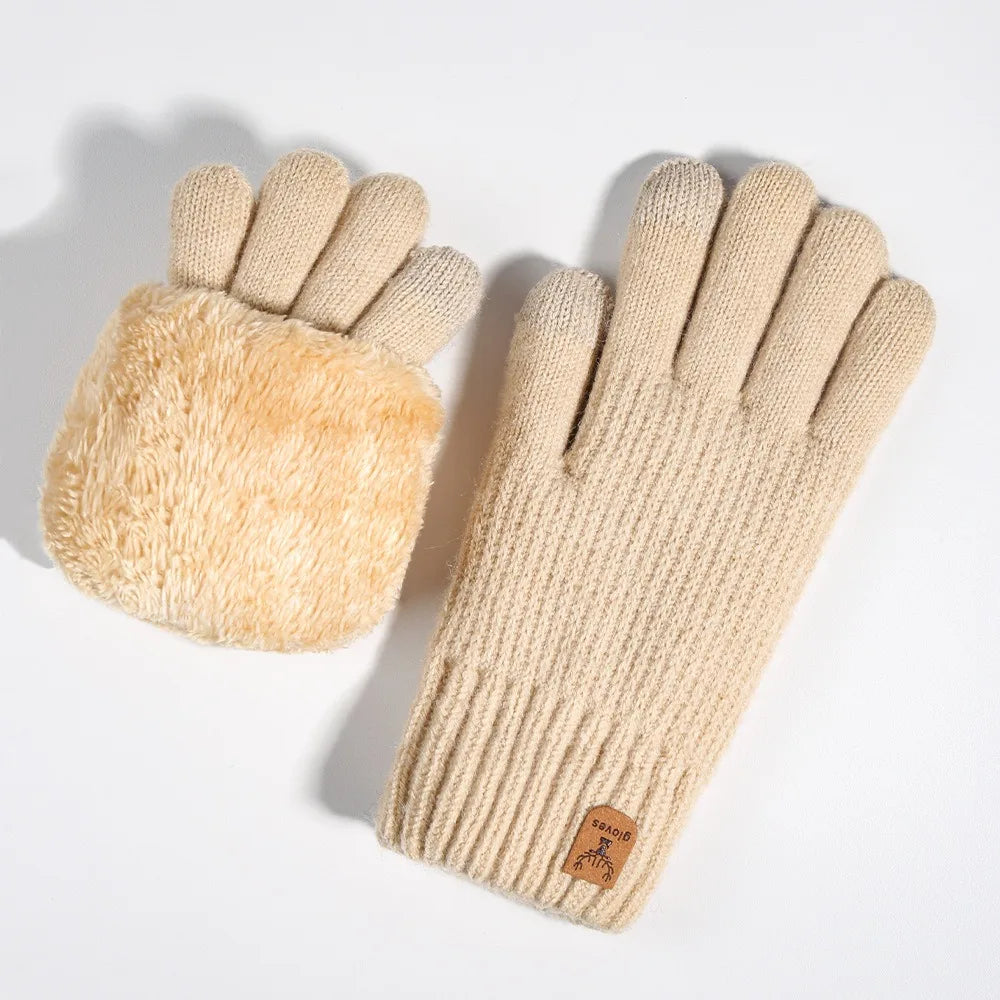 A pair of beige knit gloves with a fluffy suede cuff and a brown leather tag.