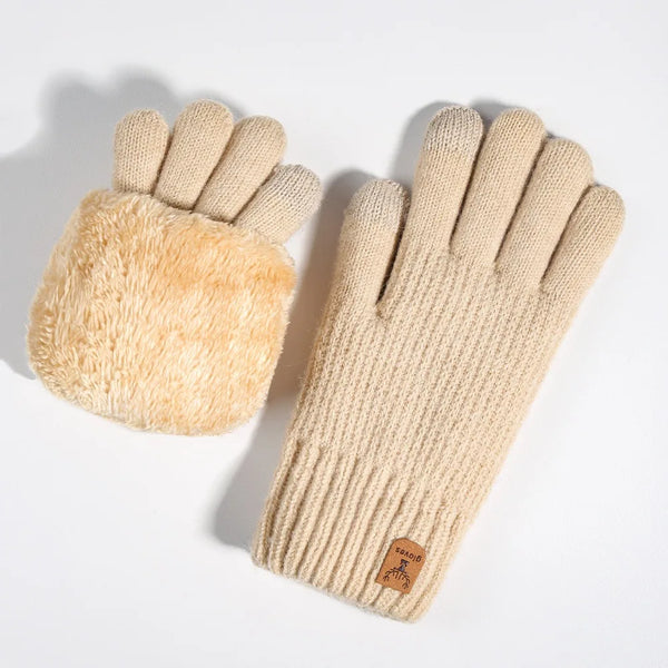 A pair of beige knit gloves with a fluffy suede cuff and a brown leather tag.