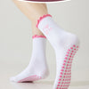 Chaussettes de yoga blanches avec des cœurs roses brodés et une adhérence antidérapante