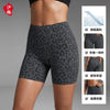 Une femme modélise des shorts de yoga à taille haute à imprimé léopard gris, mettant en valeur le tissu respirant et la compr