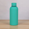 A teal double-layer vacuum thermos cup standing on a wooden surface.