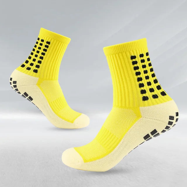 Un par de calcetines deportivos de fútbol amarillos brillantes con patrones a cuadros negros, vistos de lado.