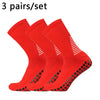 Three pairs of bright red performance football socks laid out for display