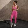 Model trägt einpinkes Zwei-teiliges Sport-BH mit Kontrastrand und enganliegende Leggings in einem Studio.