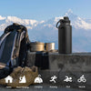 A black insulated stainless steel vacuum water bottle is shown next to a backpack and hiking boots against a mountain backdro