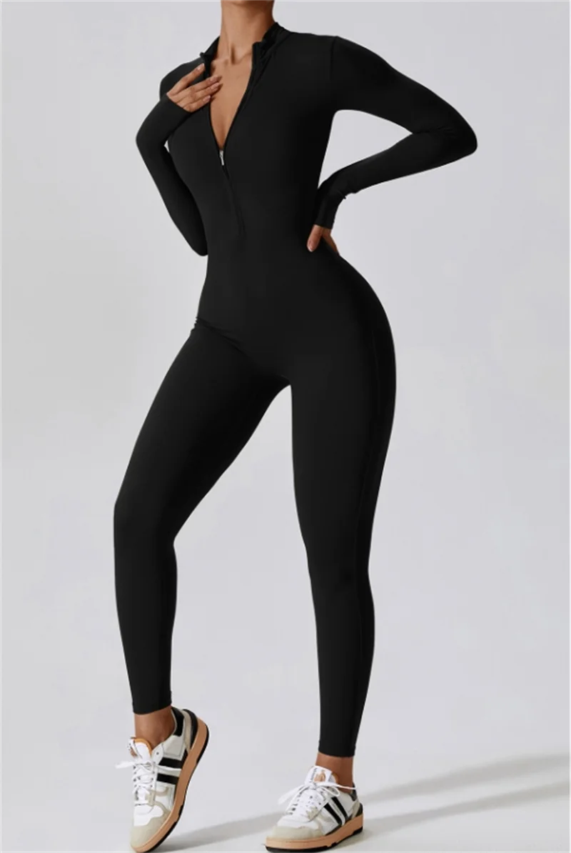 Model in black half-zip yoga jumpsuit and white sneakers.