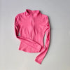 A bright pink long-sleeved zip-up jacket for yoga and fitness.