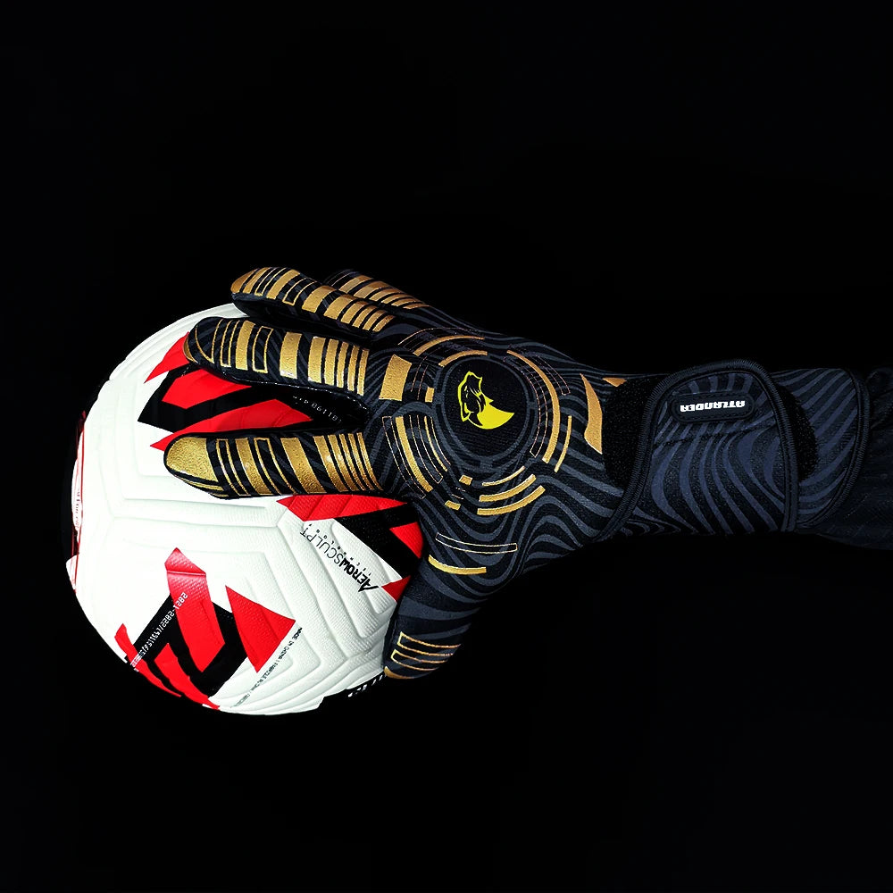 A close-up of high-performance goalkeeper gloves with gold and black accents, shown gripping a soccer ball against a black ba