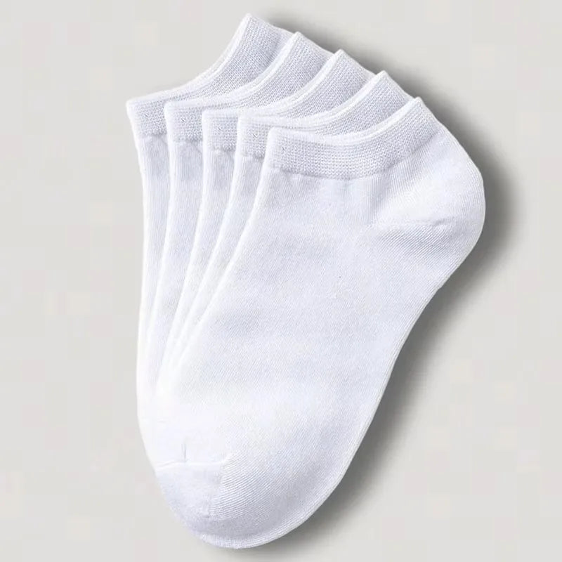 Una pila de calcetines de algodón unisex blancos transpirables para el tobillo, vista desde arriba.