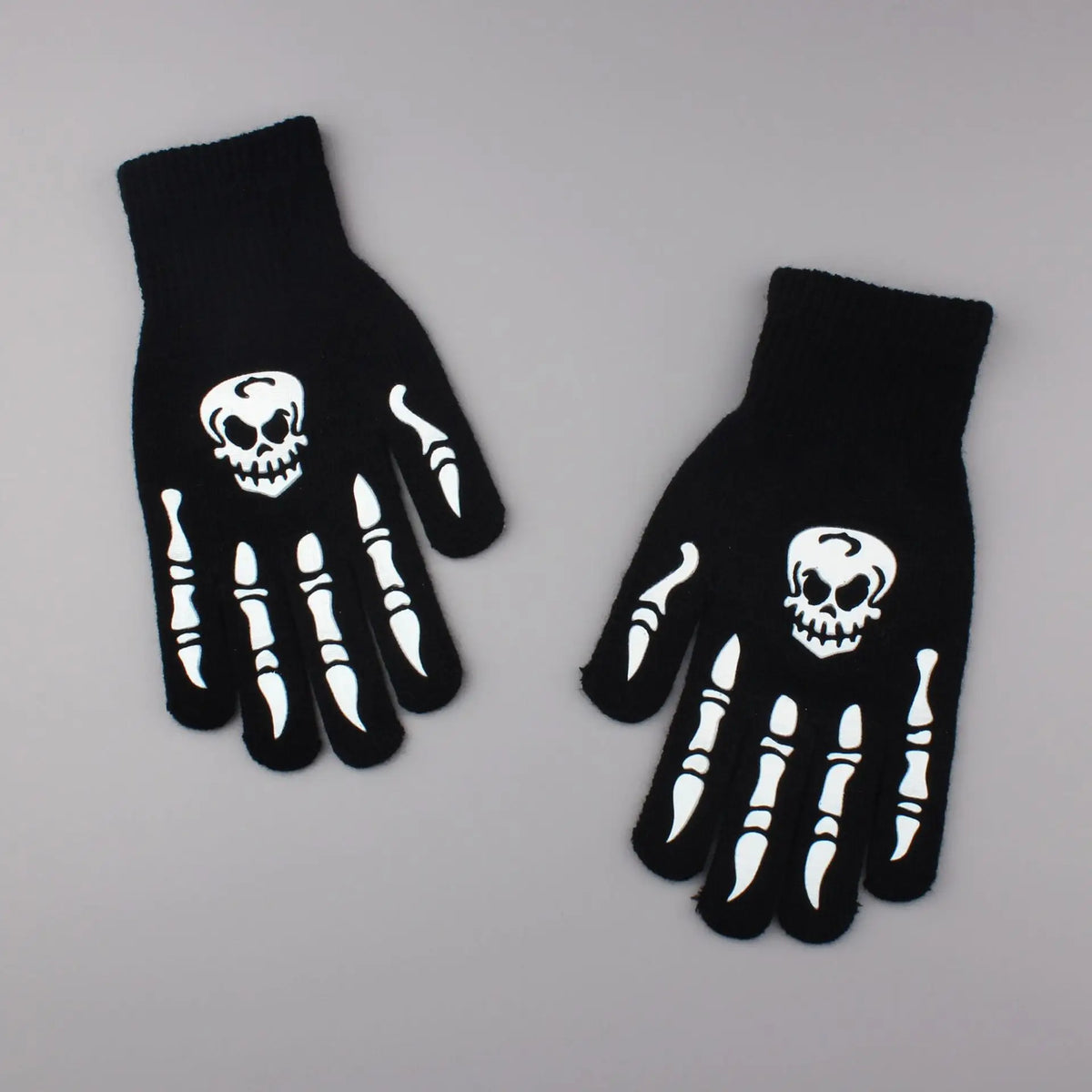 A pair of black gloves featuring white skull designs on the palm and fingers.