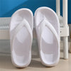 A pair of white comfort platform flip flops resting on a white surface.