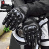 Nahaufnahme schwarzer Motorrad-Rennhandschuhe mit weißen Akzenten, gehalten auf einem Motorrad.