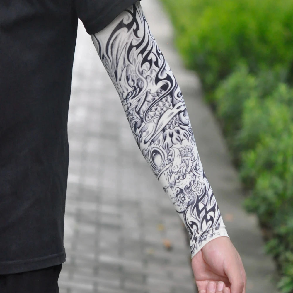 Close-up of a person's arm displaying intricate black and white traditional tattoo sleeve designs.
