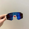 A hand holds a pair of blue-tinted sports sunglasses with white frames against a light background.