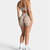 A woman models leopard print seamless yoga shorts and a matching crop top.