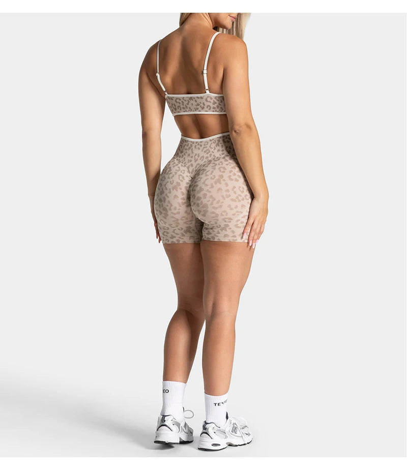 A woman models leopard print seamless yoga shorts and a matching crop top.