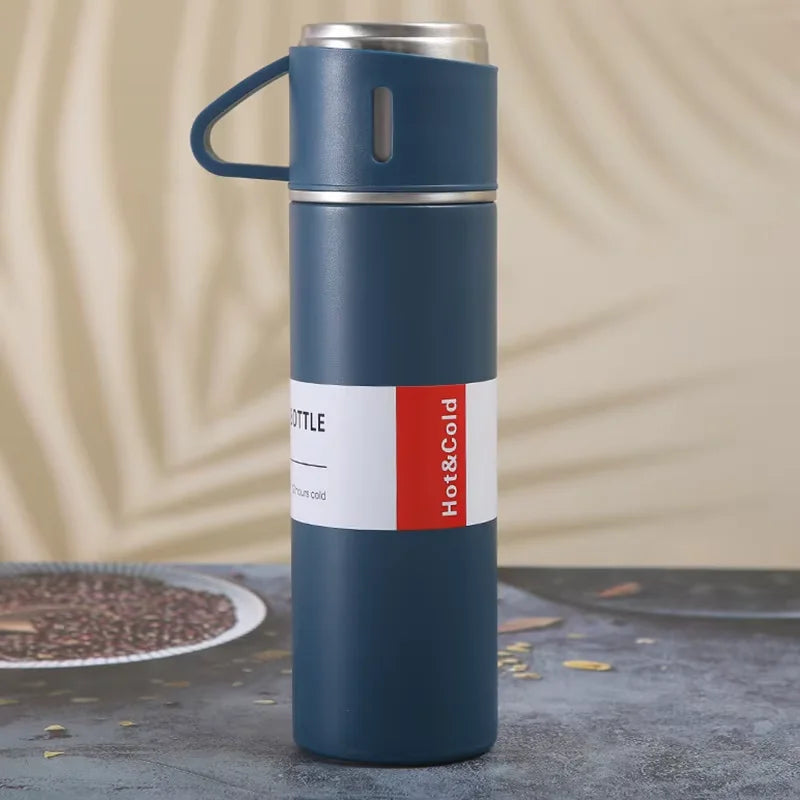 A dark blue stainless steel vacuum flask with a blue handle and red text indicating hot and cold functionality.