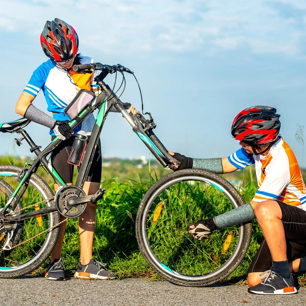 Ein Radfahrer mit Helm und Schutzärmeln justiert das Lenker eines Fahrrads im Freien.