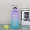 A purple sports water bottle with a straw and motivational text printed on it, sitting next to a lime slice.