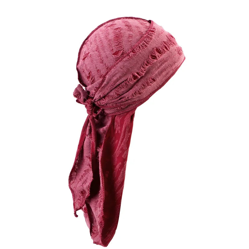 A deep burgundy velvet durag head wrap with frayed edges, styled as a pirate bandana.