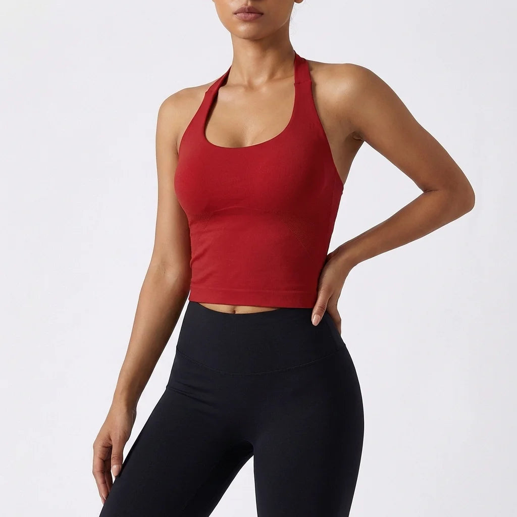 A model wearing a red seamless yoga sports bra and black leggings.