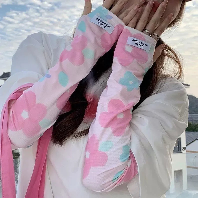 Pink and white floral ice silk sun protection arm sleeves being held by a person.
