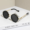 Gold-toned polarized round sunglasses with black lenses and silver accents displayed on a white box.
