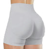 A close-up view of light gray high-waisted yoga shorts worn by a person.
